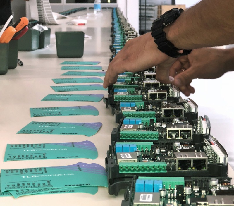 The operator inserts the TLB PROFINET IO weight transmitters into the  testing station. 